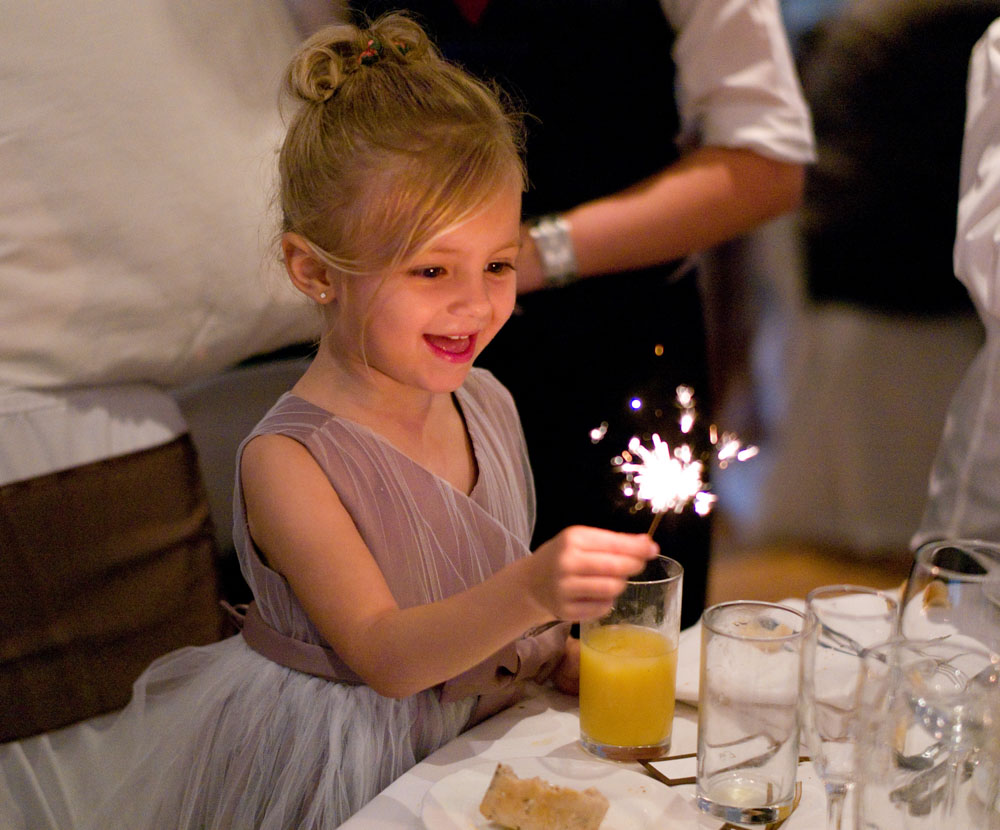 Bride's daughter with a sparkler in the wedding breakfast