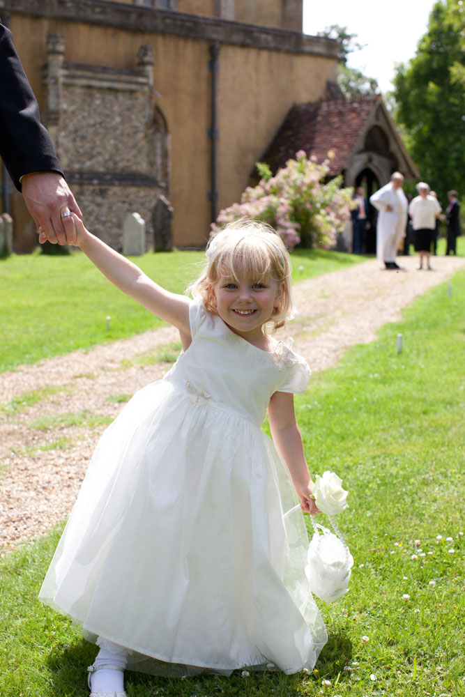 Bridesmaid by the church with a big smile - by Leeds, West Yorkshire wedding photographer