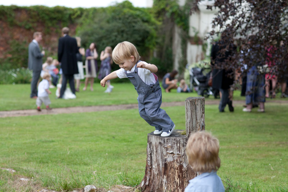 Little boy about to jump from a tree stump chair