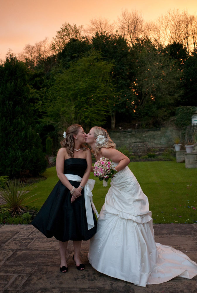 The Bride kisses a bridesmaid for a funny photo by a professional wedding photographer based in Leeds, West Yorkshire