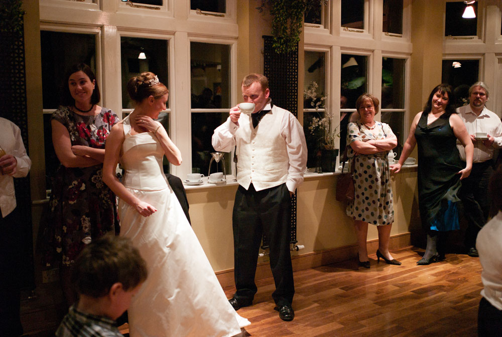 The groom has a cup of coffee