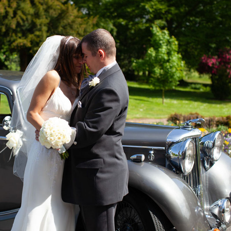 The couple by the wedding car - wedding photography Leeds