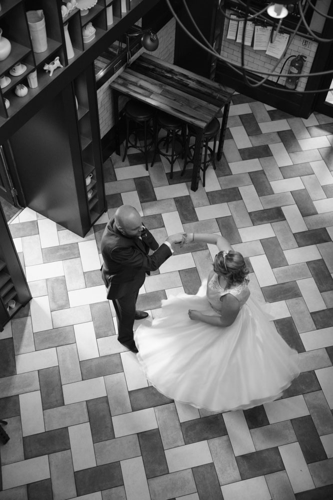 Groom twirls the bride for a photo from above