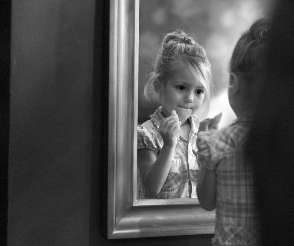 Bride's daughter make up by the mirror