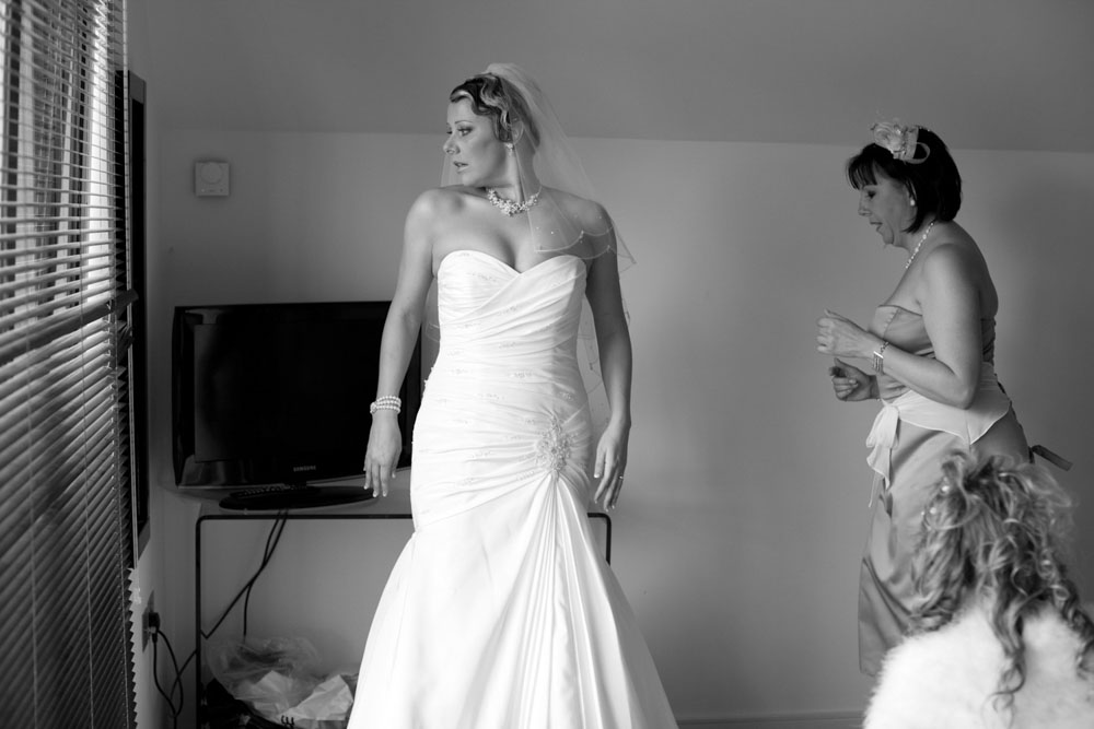 Bride looks at her dress in the mirror