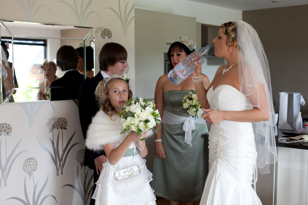 Bride drinks from bottled water