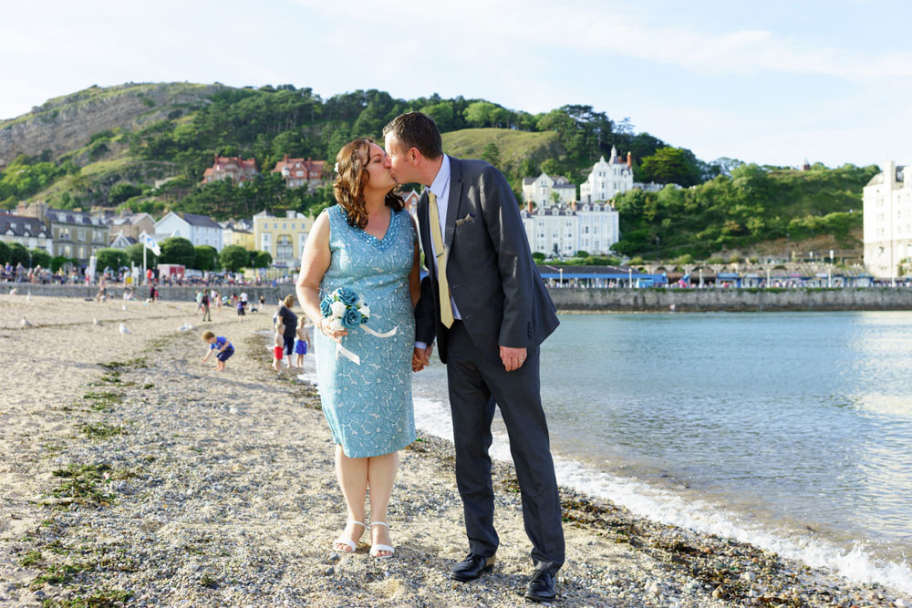 Couple kiss on the beach by West Yorkshire wedding photographer