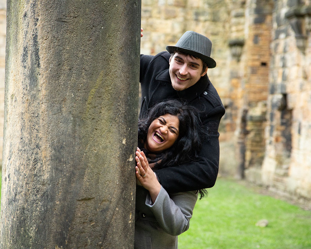 Zehra and Richard sharing a final playful moment at Kirkstall Abbey before their Leeds wedding.