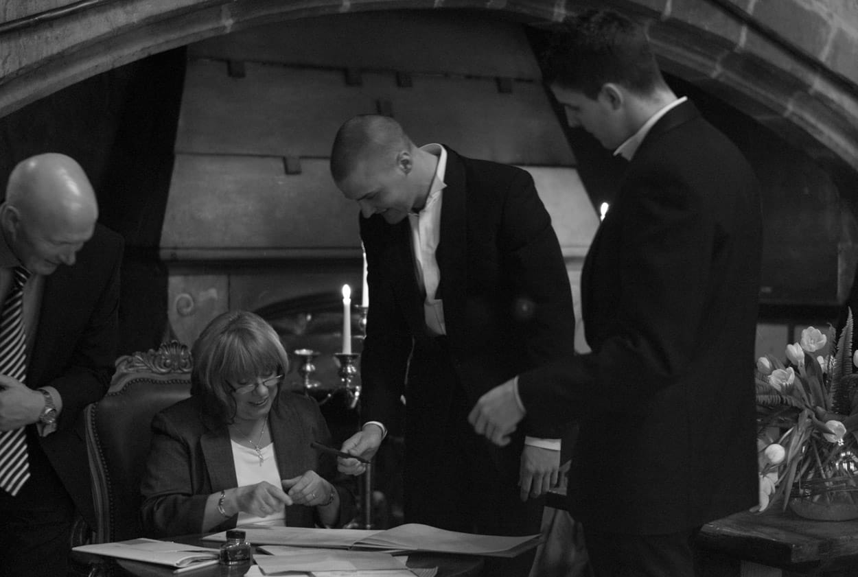 The groom’s sons sign the register as witnesses during the ceremony.