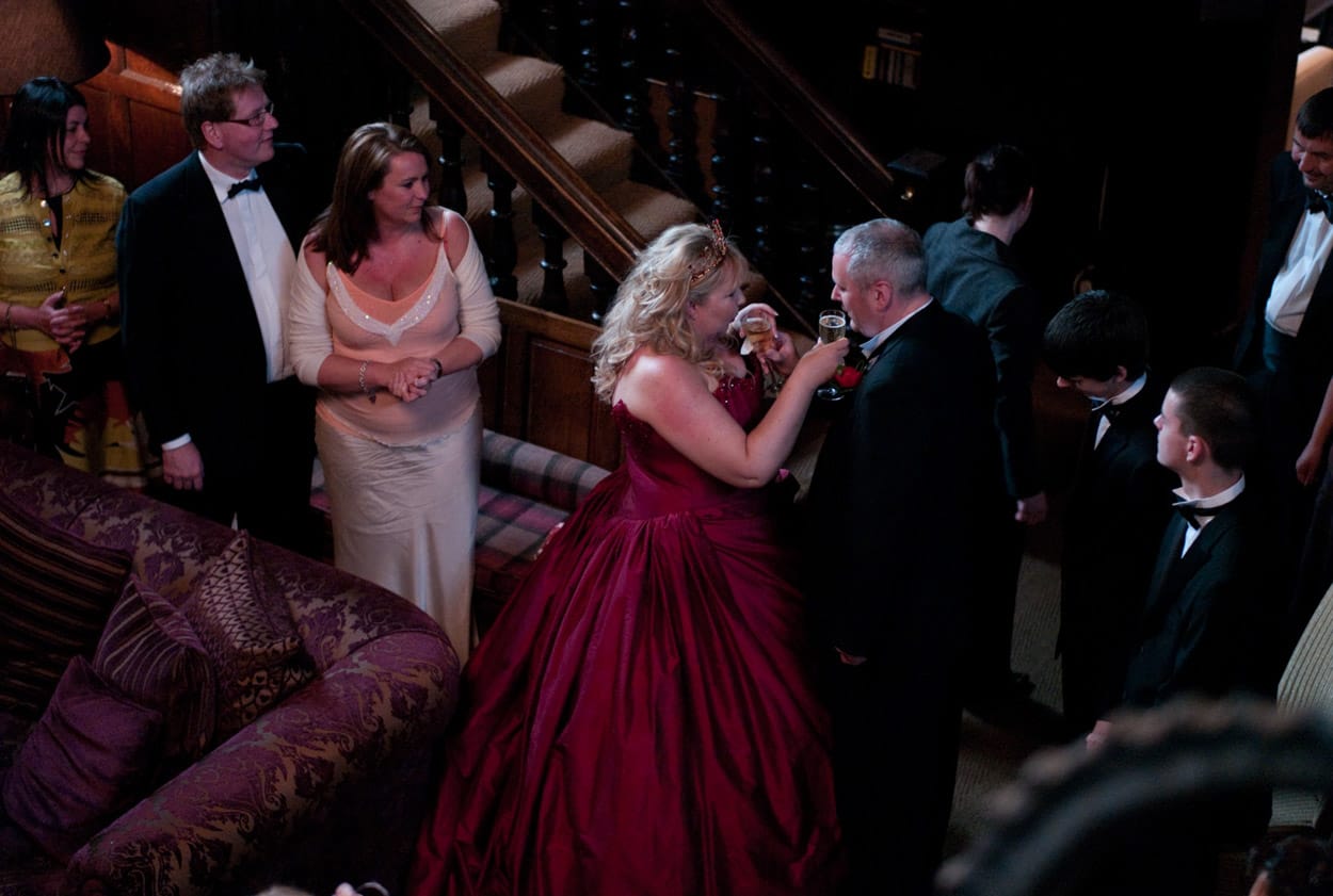 Overhead view of Nikki and Mike sharing champagne on the balcony at Mitton Hall.