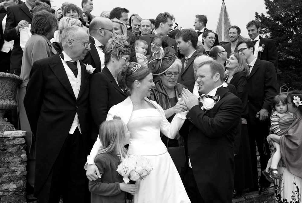 Guests gather casually, chatting and smiling on the stone steps outside the venue.