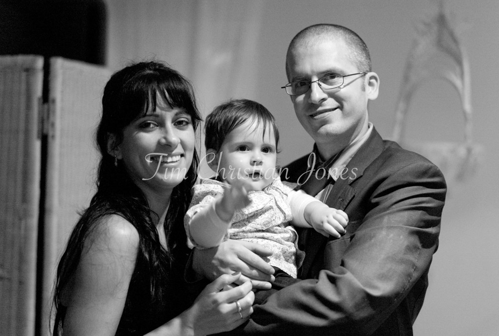 Guests pose proudly with their young son, his cheeky grin stealing the frame.