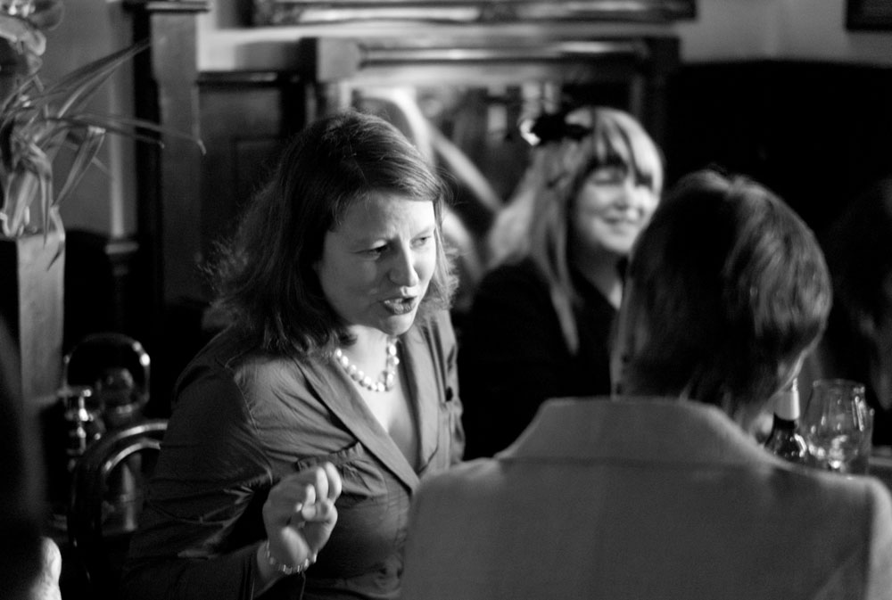 Guests chat and laugh inside Simonstone Hall Hotel in black and white.