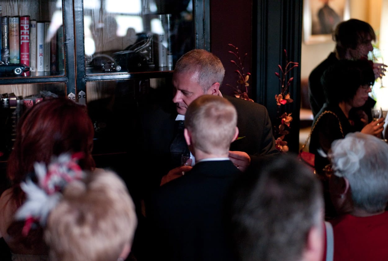 Groom laughing and mingling with friends and family.