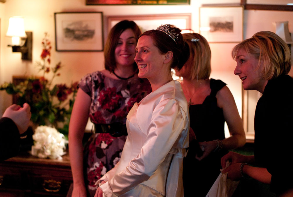 The bride shares a warm, joyful moment with friends inside the venue.