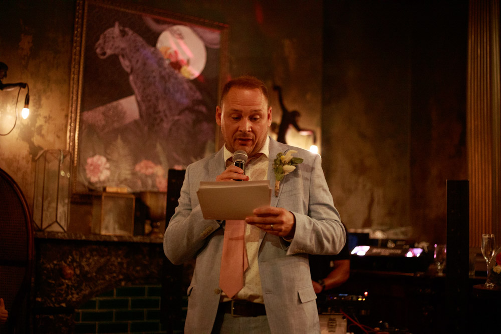 Groom reads from his notes during wedding speech