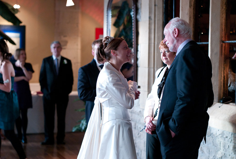 The bride mingles and chats warmly with her friends, smiling.
