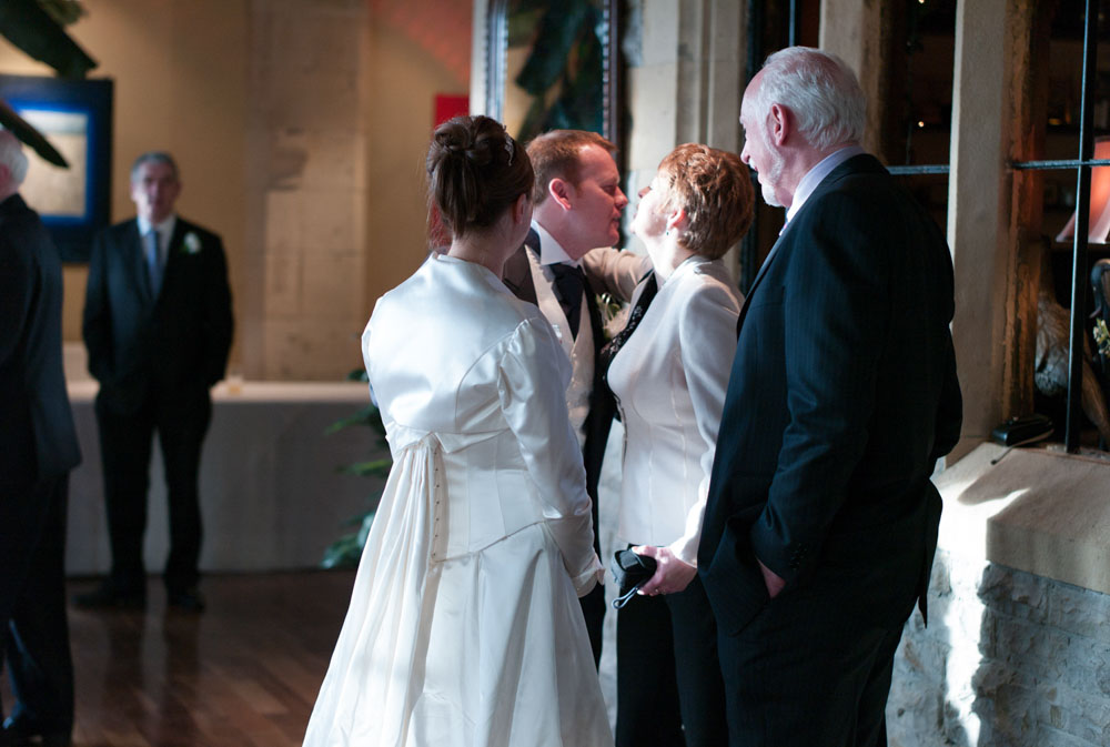 The groom steps into the scene, surrounded by friends and the bride.