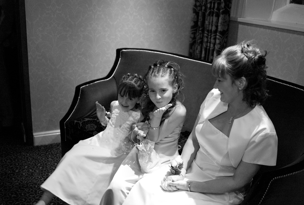 Bride and daughters in monochrome, one blowing a kiss