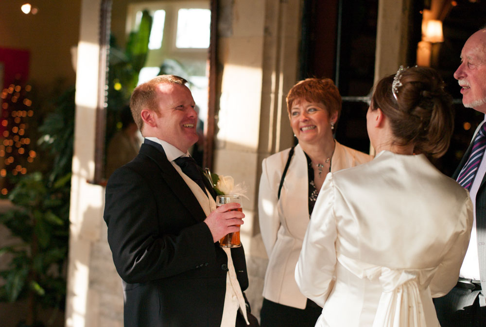 The groom bursts out laughing during a casual chat — the moment frozen in time.