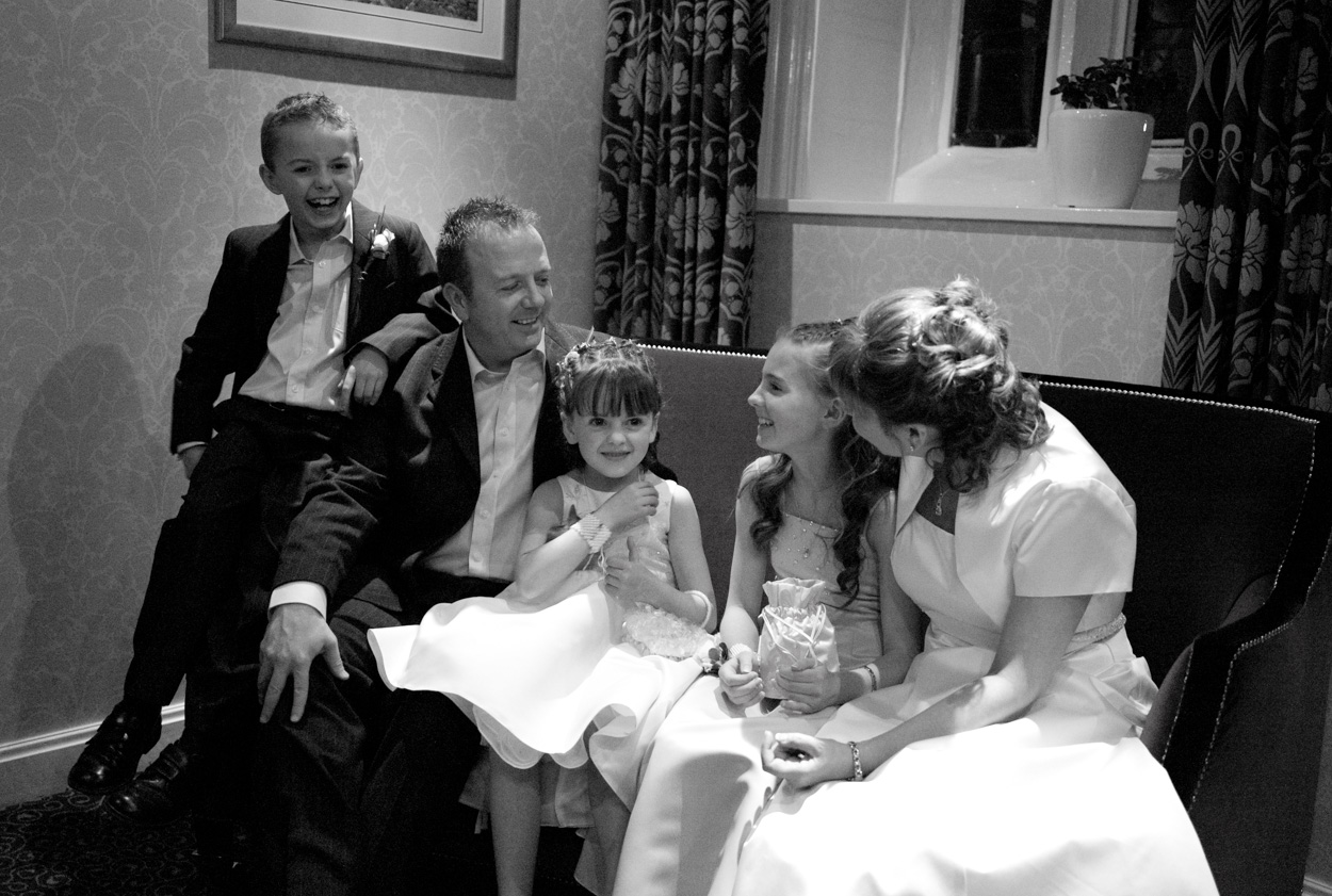 Full family fun group seated on sofa in black and white