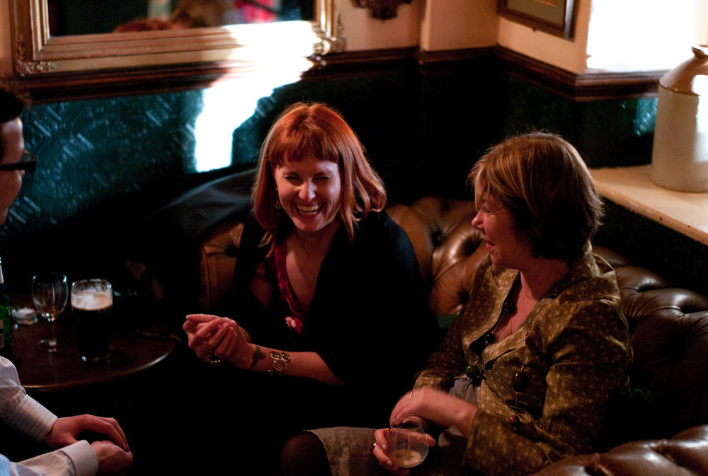 Guests relax on cosy sofas in Simonstone Hall, smiling and enjoying the afternoon.