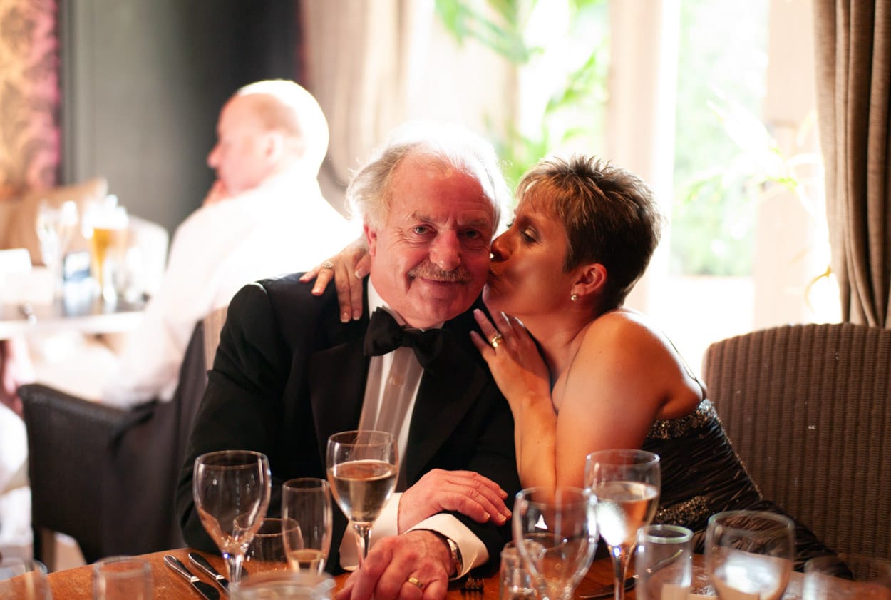 Nikki and Mike sharing a casual moment at a reception table.
