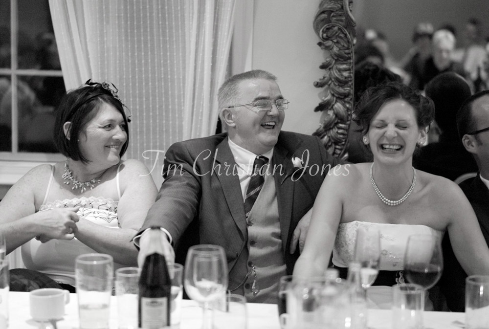 Julie and her parents share a moment of laughter, visibly enjoying the speeches.