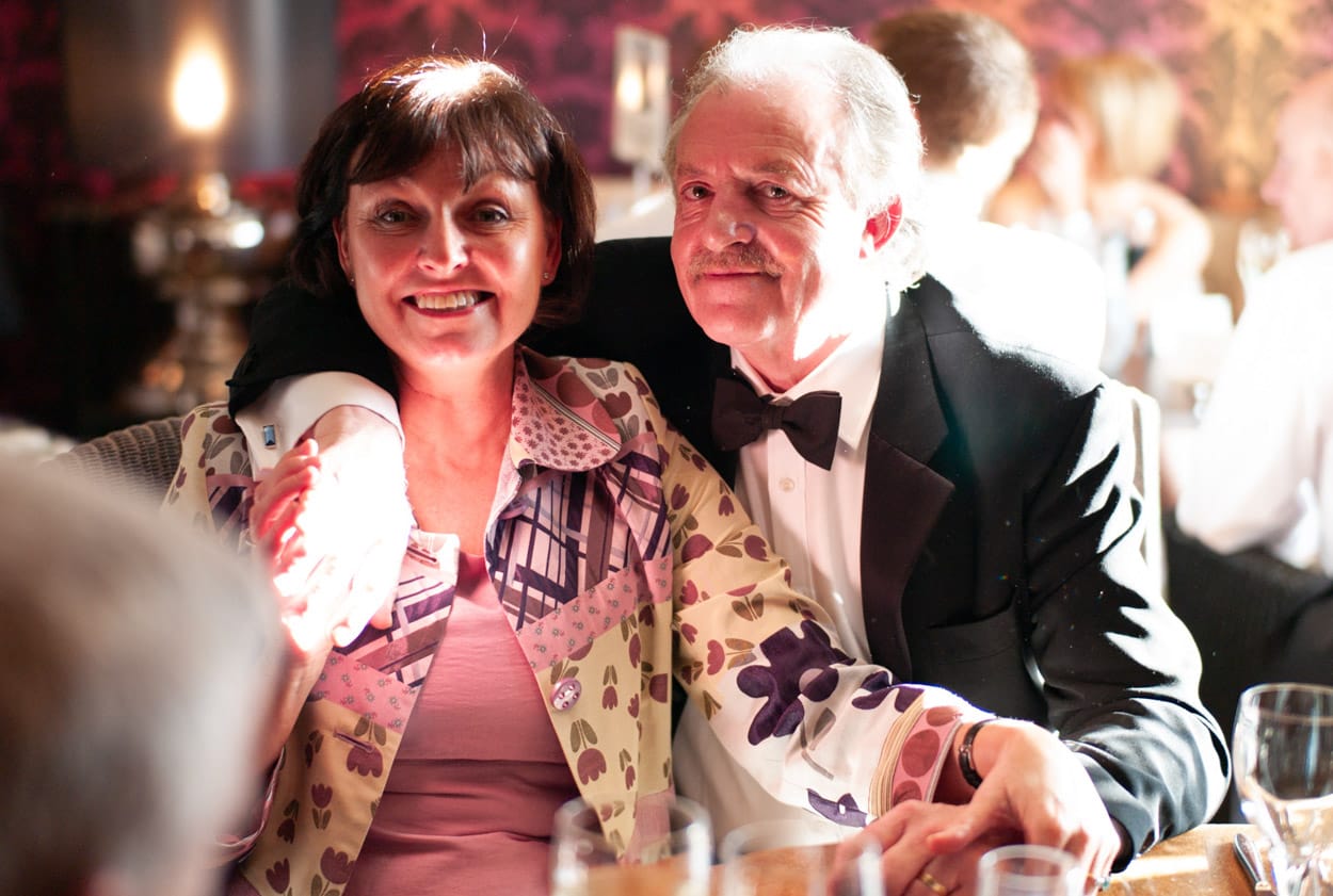 Guests smiling and posing at their reception table.