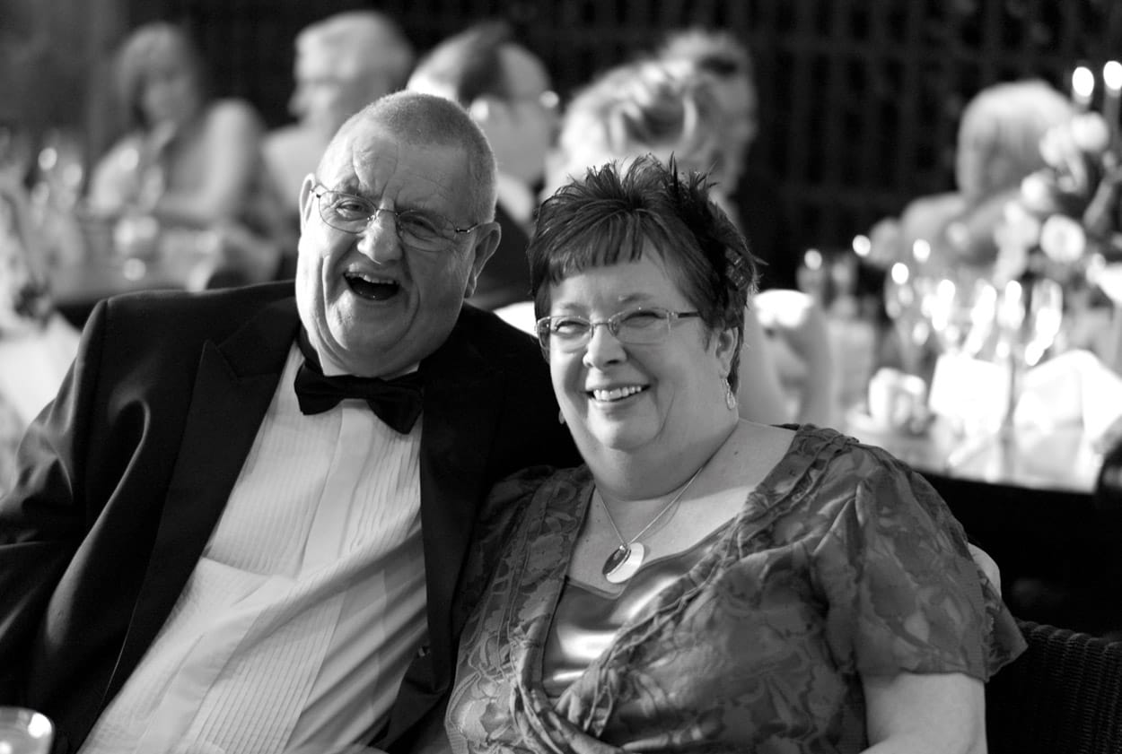 Guests smiling warmly for a relaxed table photo.
