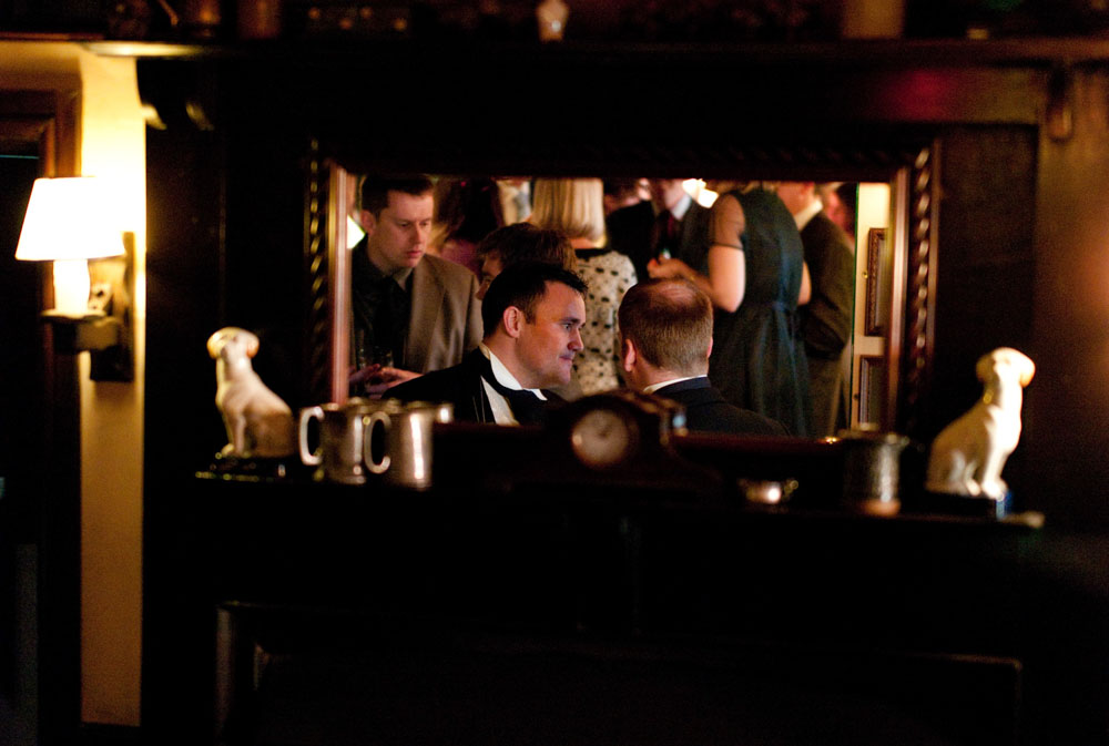 A mirror reflects a scene of guests and details inside this Yorkshire wedding venue.