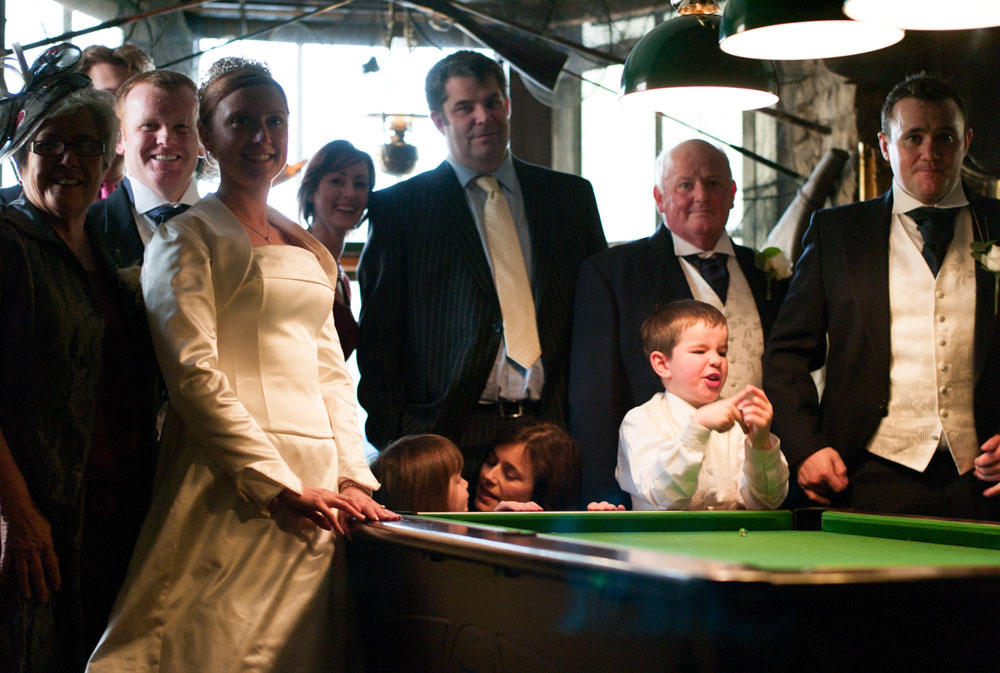 The couple and their friends pose for a happy photo beside the snooker table.