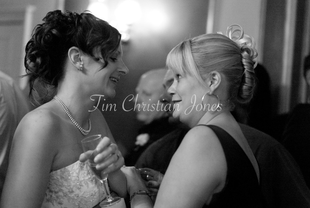 A quiet moment as Julie leans in to chat with a close friend during the reception.