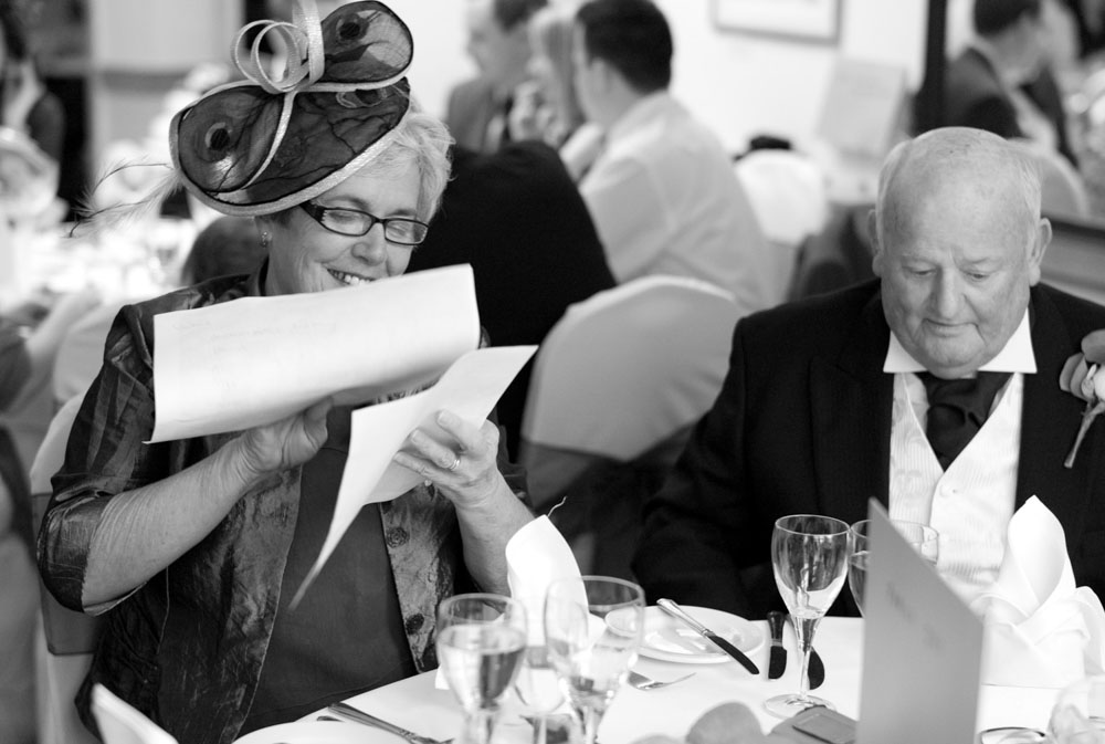 The parents of the bride or groom sit smiling at their table.