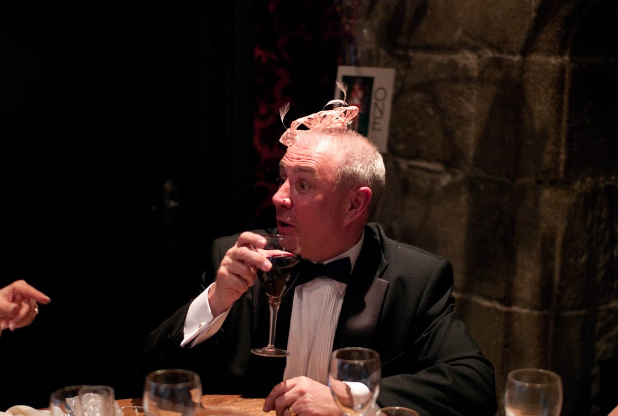 Close-up of a male guest resting his chin near his wife’s intricate hair detail.