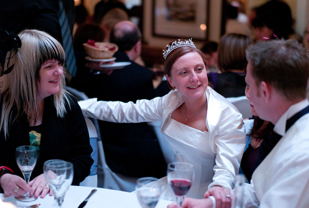 A colour image of the bride smiling warmly with two friends during the wedding breakfast at this Yorkshire venue.
