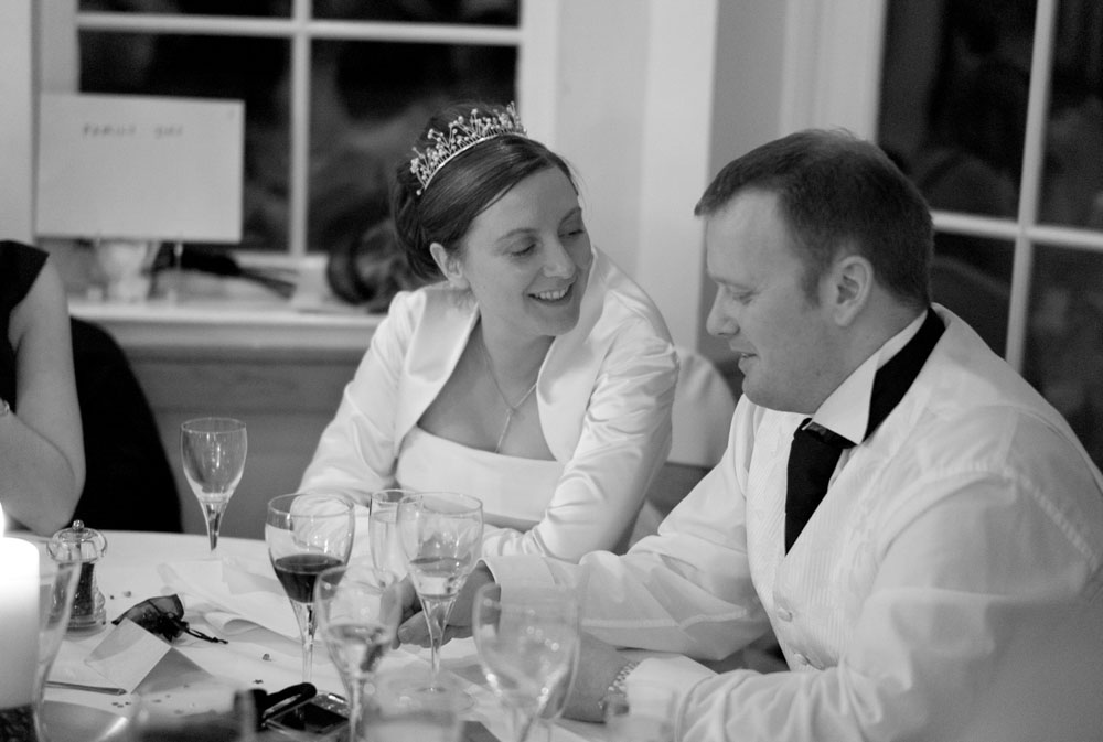 The couple sit side by side before the speeches begin, the groom looking slightly nervous.