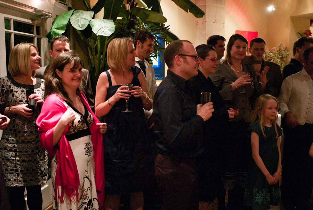 Wedding guests gather along the edge of the dancefloor, waiting for the first dance.