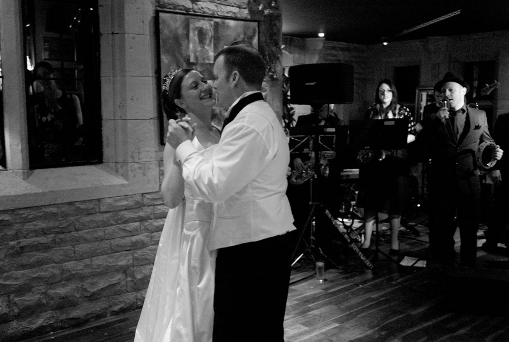In black and white, the couple share their first dance while the jazz band plays at this Yorkshire wedding.