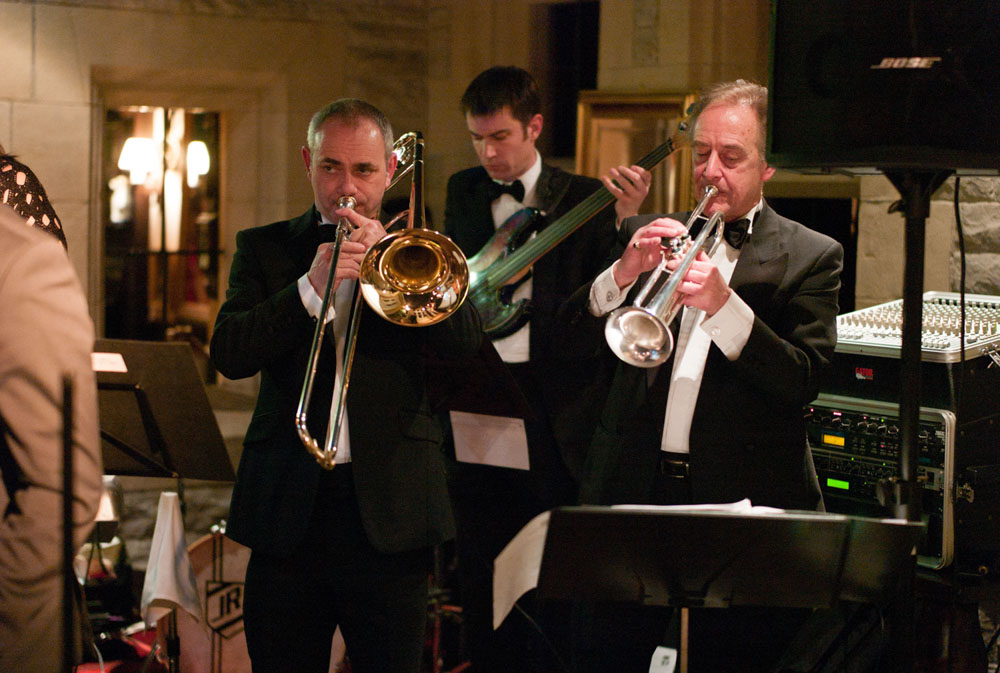 The wedding jazz band continues to play as guests watch and dance.