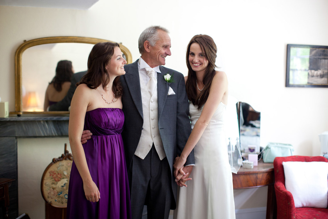 Bride and daughter sharing an intimate nose-to-nose moment during bridal prep, smiling in their dresses before the ceremony, captured by Leeds wedding photographer, Tim Christian Jones Photography