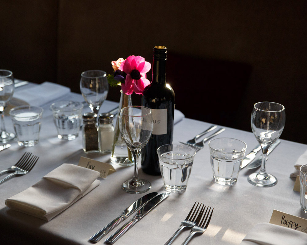 Rustic wedding breakfast table setting in a low light upstairs pub setting, captured naturally by a Leeds wedding photographer.