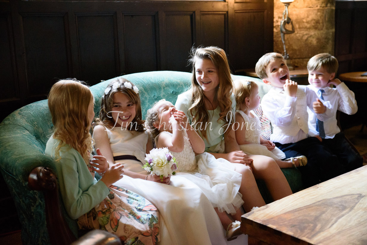 Children sitting together on a sofa during family photos, captured in a natural candid moment.