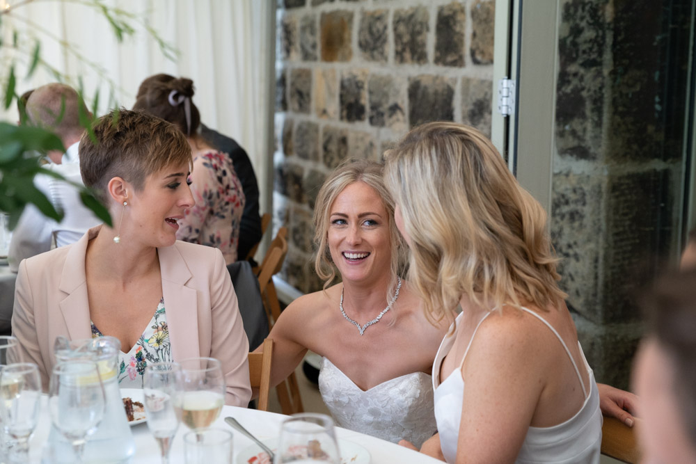Bride greets guests at the wedding breakfast tables in the marquee at the Chilli Barn