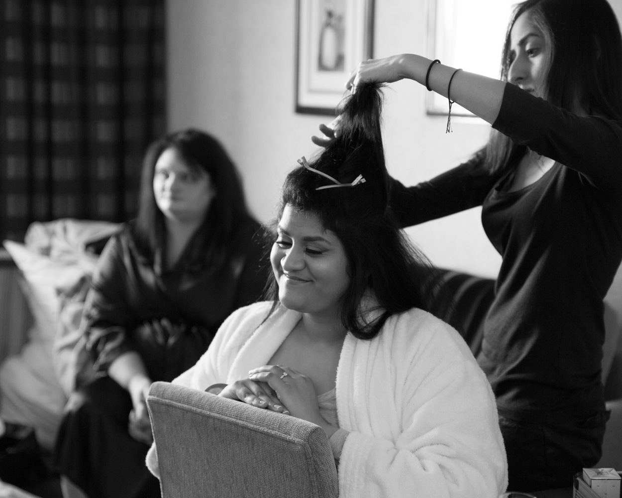 Zehra smiles brightly in her dressing gown as her hair is styled at Crowne Plaza Leeds, showing her engagement ring.