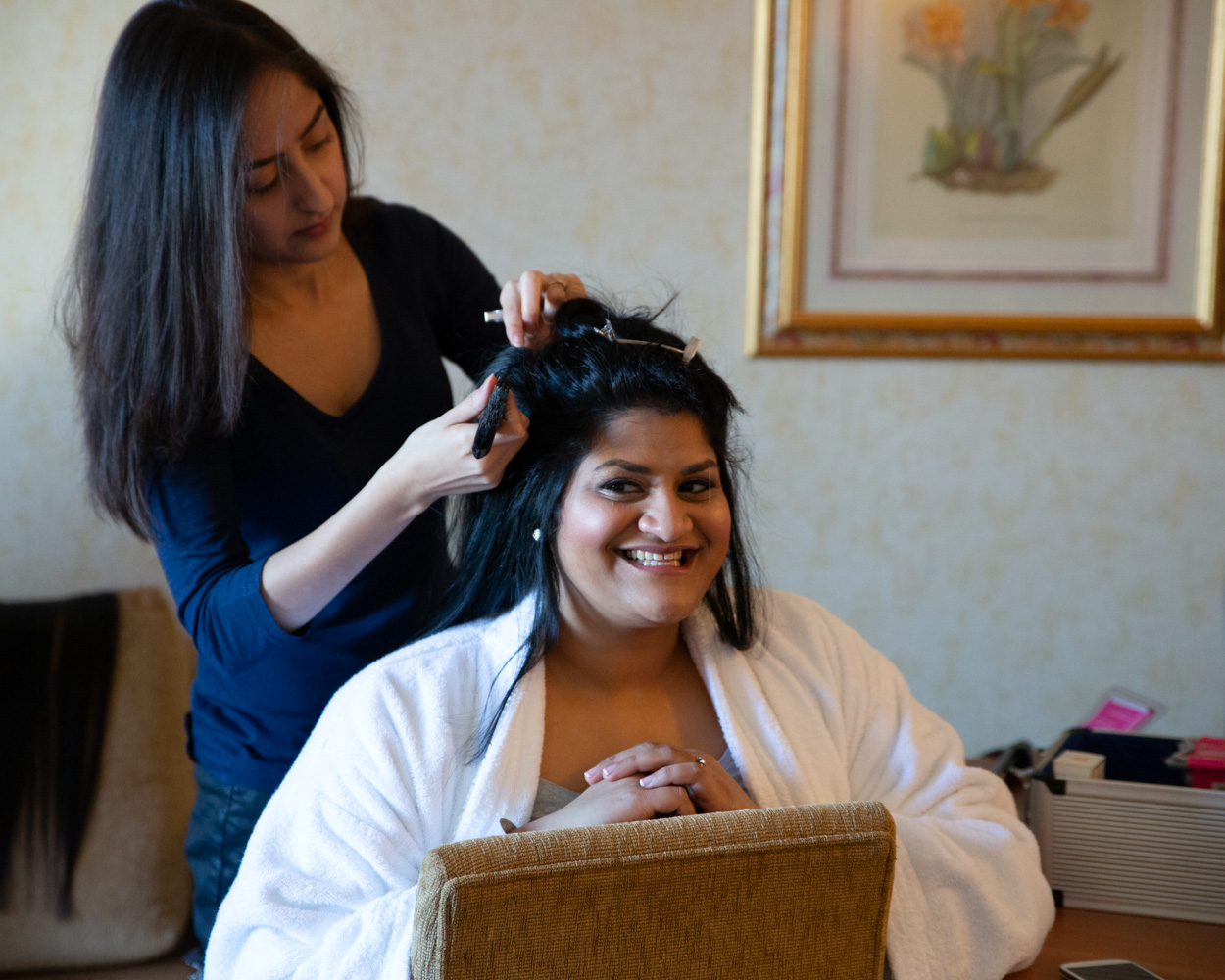 Zehra smiles with excitement in the bridal suite, full of joy ahead of her wedding at Crowne Plaza Leeds.