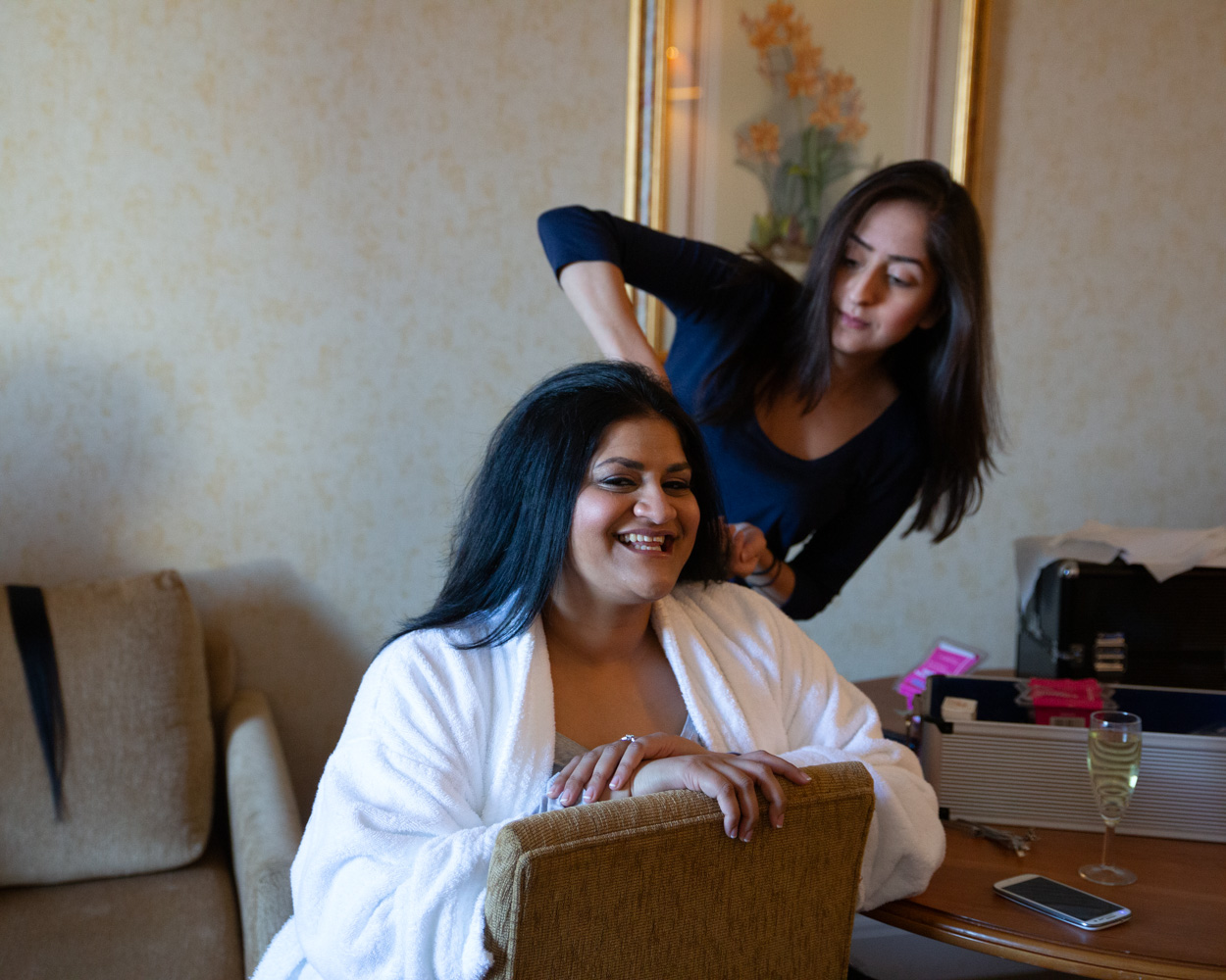 Zehra laughs aloud as friends arrive at the suite, hair jewellery sparkling in her styled hair.