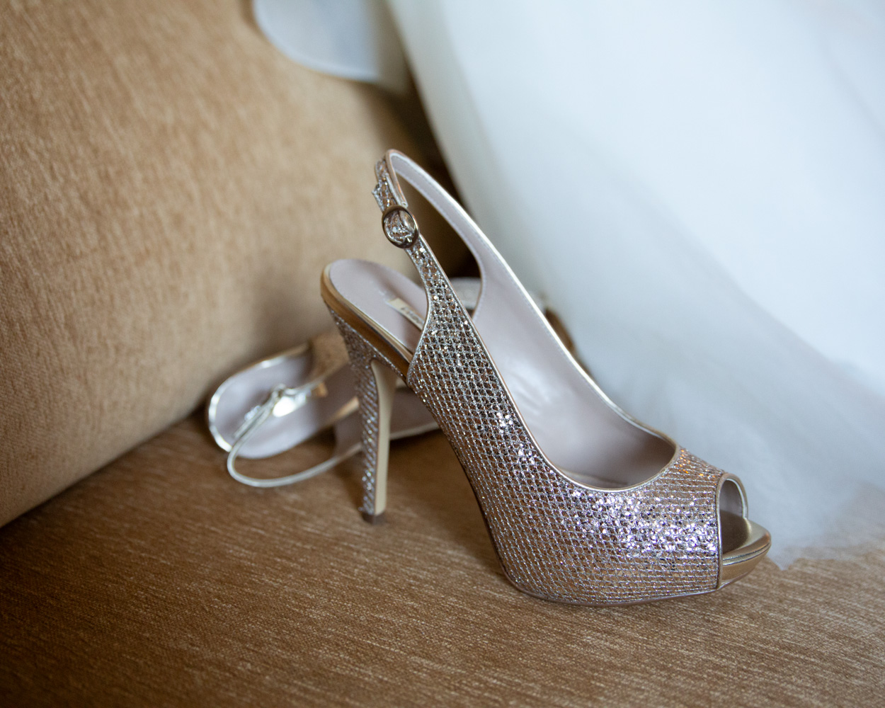 Four bridesmaids in pink dresses sitting on the sofa, smiling together
