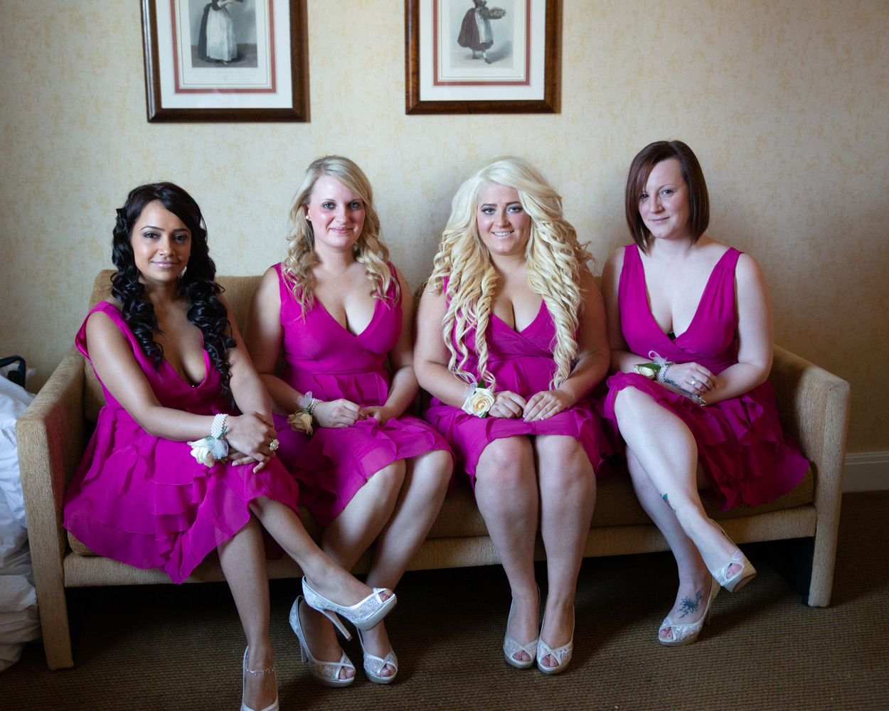Two bridesmaids in pink dresses taking a cheerful selfie