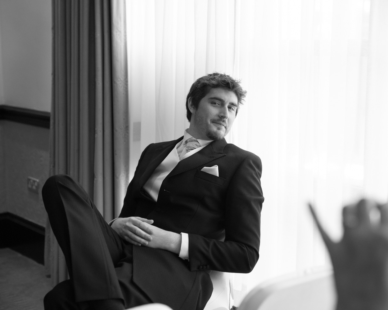 Groom places the wedding ring on bride’s finger during ceremony, both smiling warmly